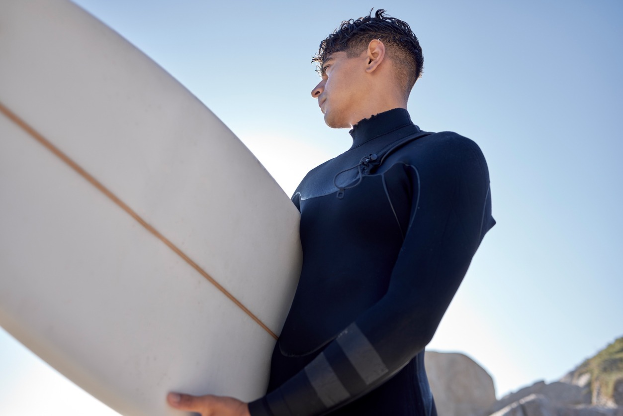 Surfing, beach and man with blue sky outdoor for water sports