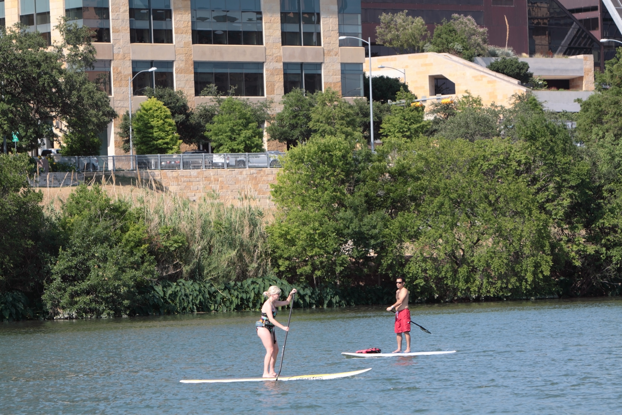 People enjoying stand up paddling on Lady Bird Lake in Austin, Texas