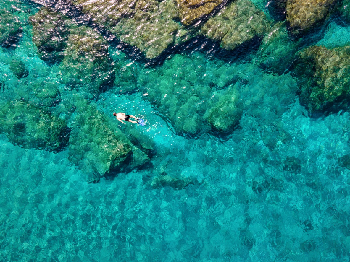 A man snorkeling in the emerald waters of the Aegean Sea