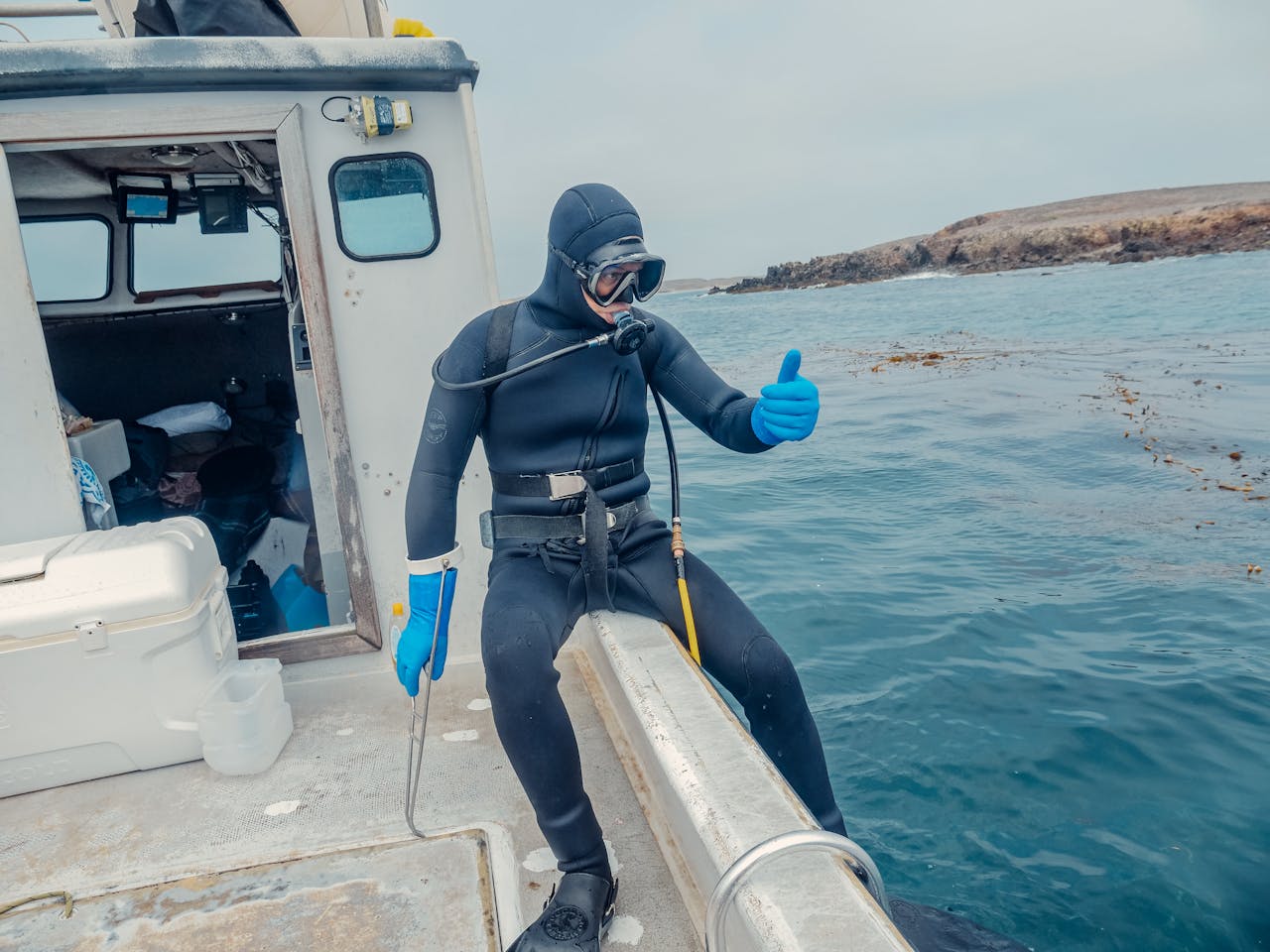 Person in Scuba Diving Gear Sitting on a Boat