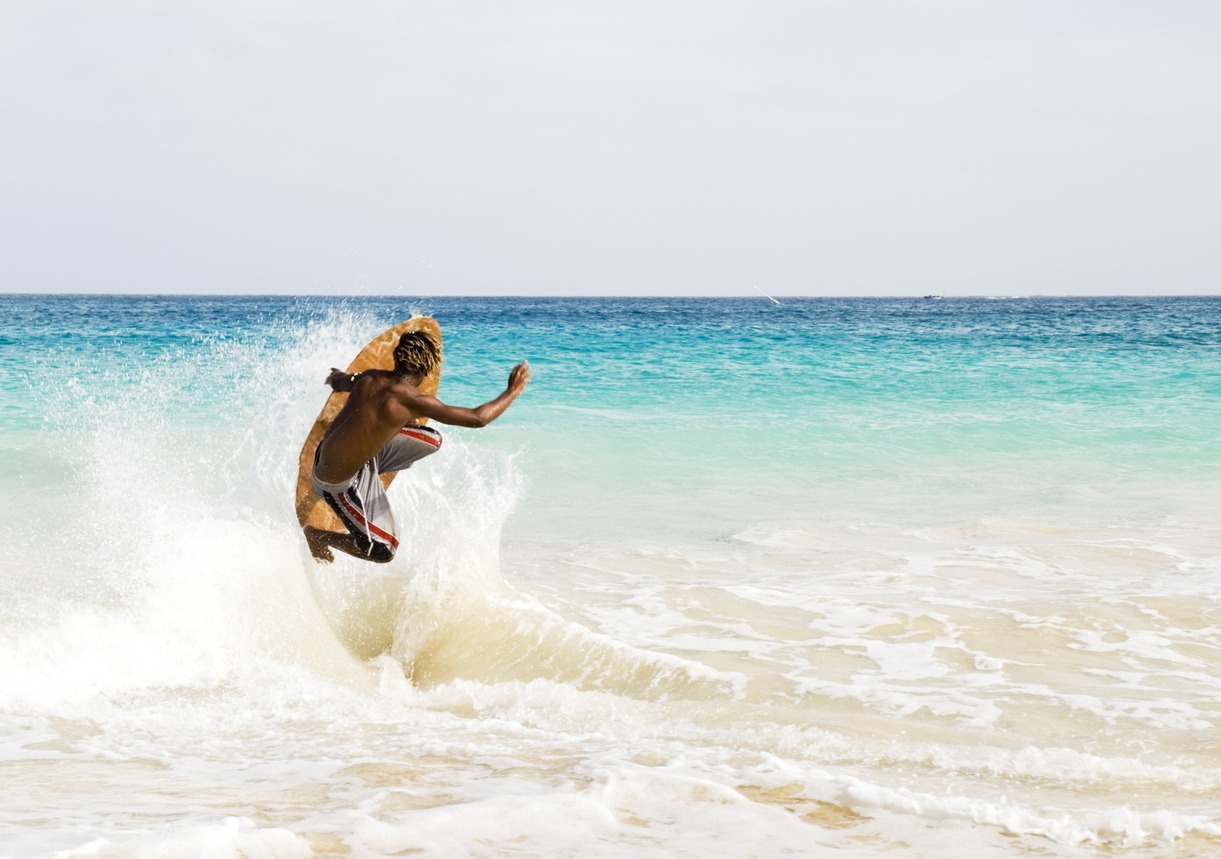 Skimboarder jumping wave