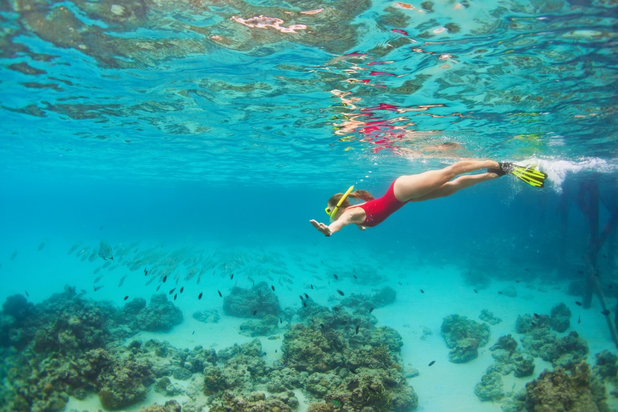 Young woman in snorkeling mask dive underwater