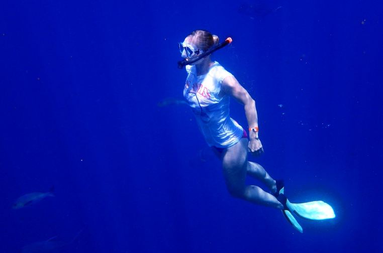 a woman snorkeling in deep blue seawater