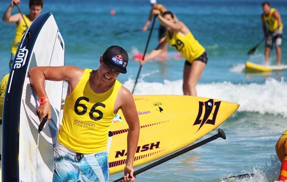 A group of paddlers wearing yellow, SUP as a sport, a man sweating
