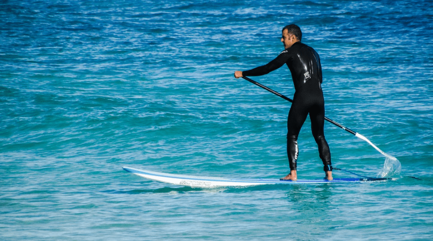 Stand Up Paddleboarding, man in black SUP attire, ocean