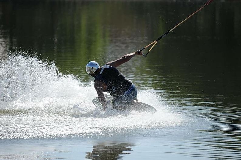 A man kneeboarding in the river