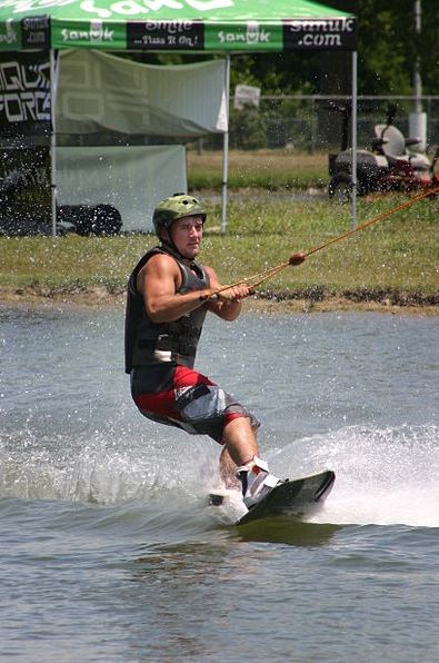 A wakeboarder towed by an overhead cable