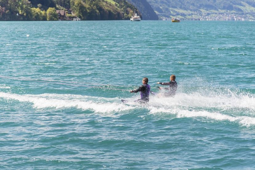 Two men kneeboarding on a lake