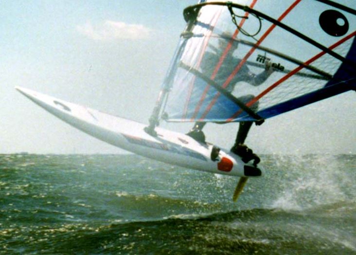 A closeup photo of a man windsurfing