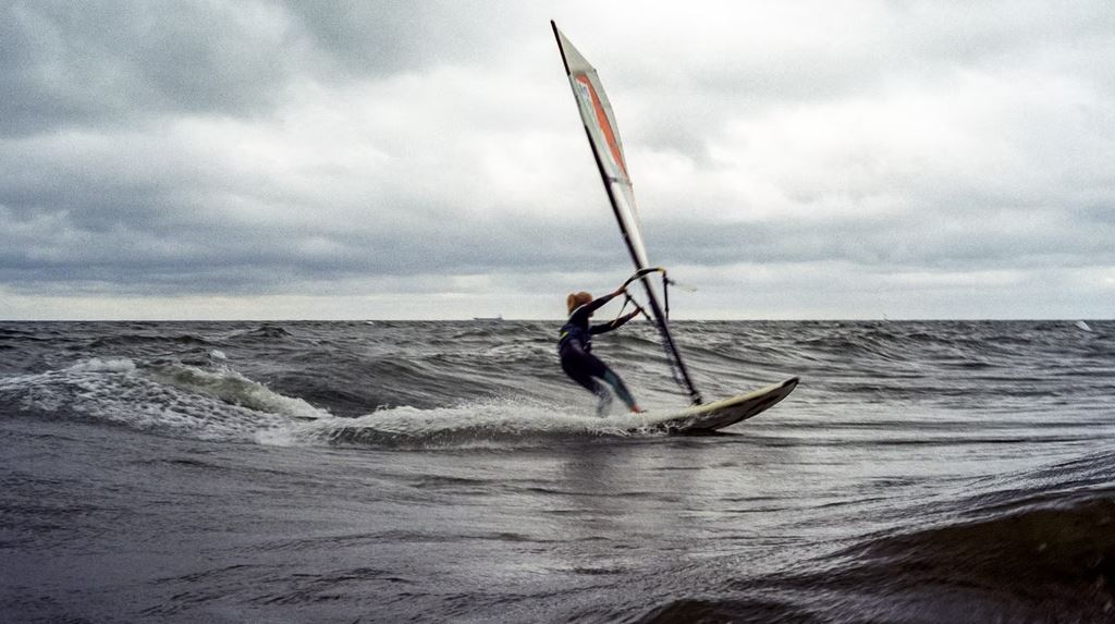 A person windsailing by the sea