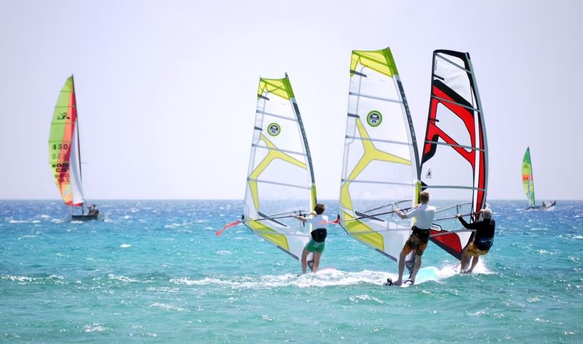 Three people windsurfing together
