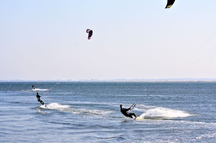 Two persons kitesurfing together