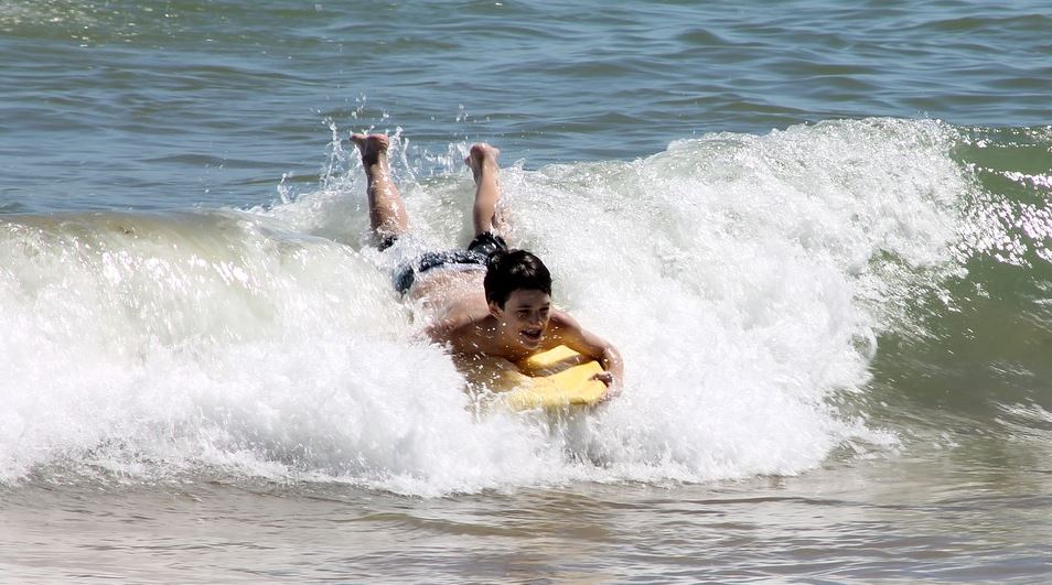 a boy riding a wave on a bodyboard