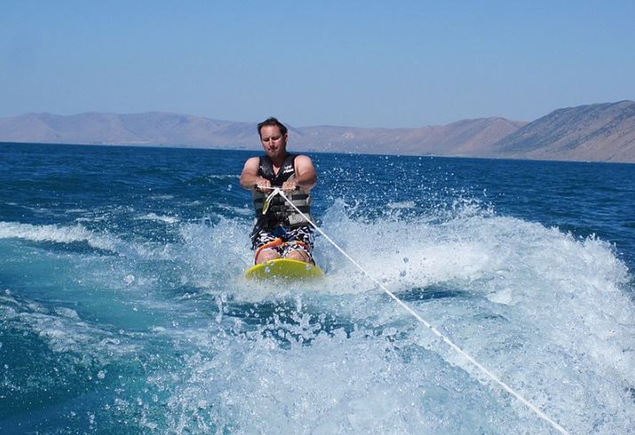 a man kneeboarding at the ocean